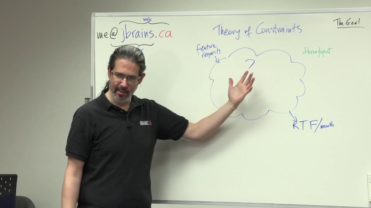 J. B. at the whiteboard, describing how Theory of Constraints helps us deliver software features sooner.